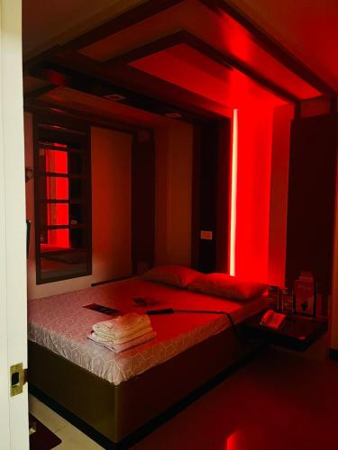 Un dormitorio con una cama con luces rojas. en Hotel Sogo - Dau, Pampanga, en Ángeles