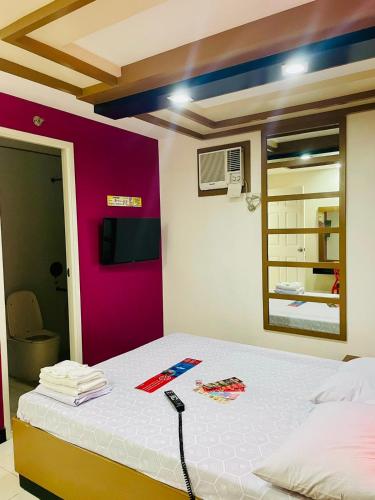 アンヘレスにあるHotel Sogo - Dau, Pampangaのベッド1台(リモコン付)が備わる客室です。