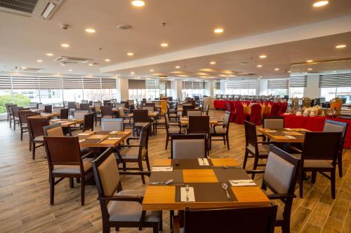 City Rise Hotel Miri في ميري: غرفة طعام مع طاولات وكراسي خشبية