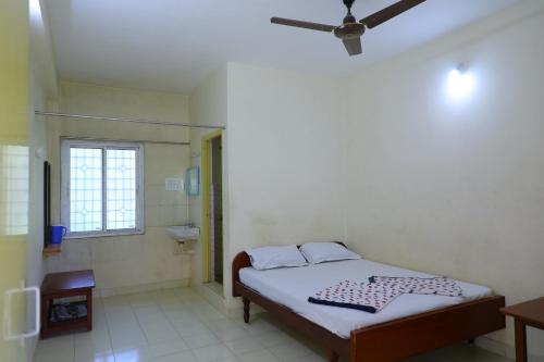 a bedroom with a bed and a ceiling fan at Aishwaryam Inn in Yercaud