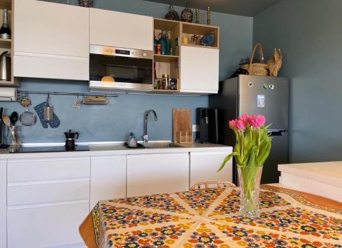 une cuisine avec une table avec un vase de fleurs dessus dans l'établissement Alloggio fronte mare vista bellissima Mentone Garavan, à Menton
