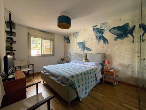 - une chambre avec un lit et un mur avec du poisson dans l'établissement Alloggio fronte mare vista bellissima Mentone Garavan, à Menton