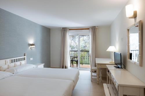 1 dormitorio con 2 camas, escritorio y TV en Villa Covelo, en Poio