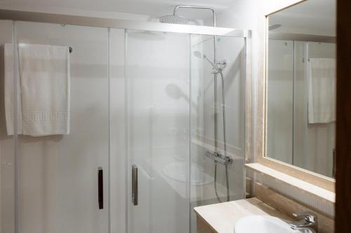 a bathroom with a glass shower and a sink at Villa Covelo in Poio