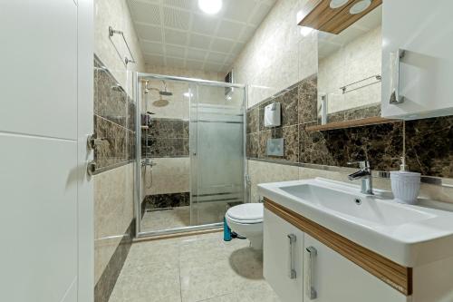 ein Bad mit einem Waschbecken, einer Dusche und einem WC in der Unterkunft Royal Babil Suites Hotel in Trabzon