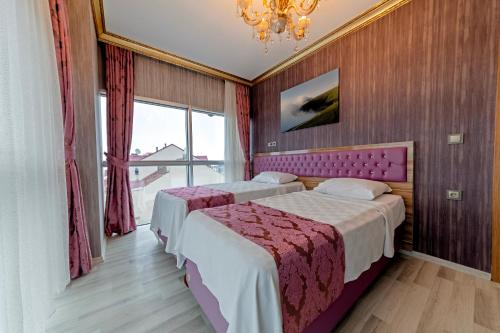 een hotelkamer met 2 bedden en een kroonluchter bij Royal Babil Suites Hotel in Trabzon