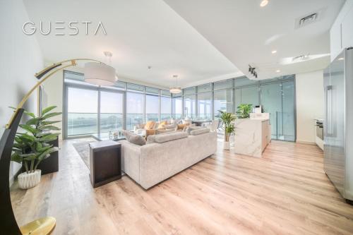 a living room with a couch and a tv at Emaar Beachfront - Beach Vista Tower, Dubai Marina in Dubai