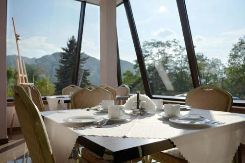 a table with chairs and a white tablecloth on it at Vena in Szczawnica