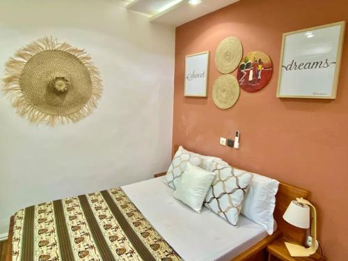 a small bedroom with a bed with a hat on the wall at Appartement Terracotta in Godomè