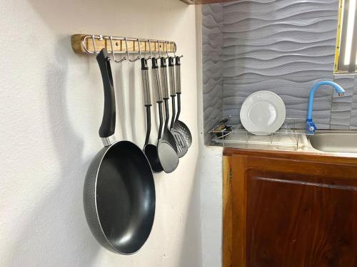 a kitchen with utensils hanging on a wall at Appartement Terracotta in Godomè