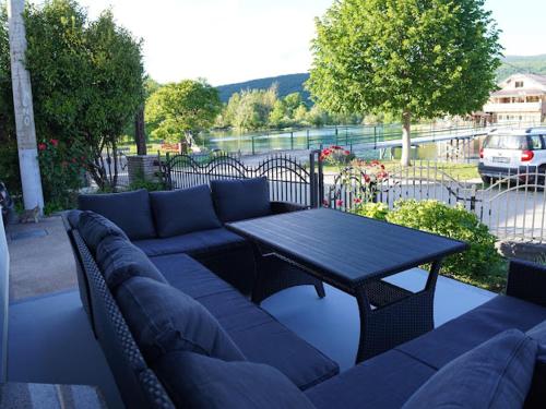 a blue couch and a table on a patio at Apartman UnaTesnim in Bihać
