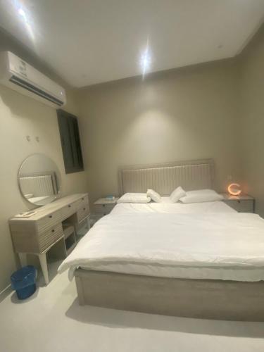 Schlafzimmer mit einem Bett, einem Spiegel und einem Schreibtisch in der Unterkunft غرفتين بدخول ذاتي in Al Kharj