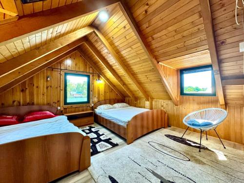 a attic bedroom with two beds and a chair at Genti House Ada Bojana in Ulcinj