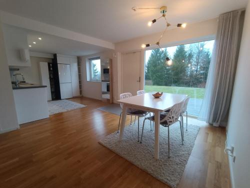 cocina y comedor con mesa y sillas en Modern, private spacious & fully equipped for 2-6 people Near forest, with kitchen, washer, pets friendly en Floda