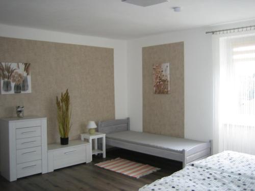 een slaapkamer met een bed, een dressoir en een raam bij Apartmány Polepy in Polepy