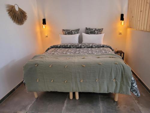 - une chambre avec un lit doté d'une couette et d'oreillers verts dans l'établissement Gîte au pied du mont ventoux, à Bédoin