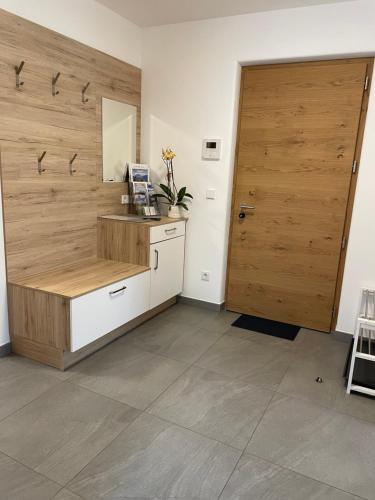 a room with a wooden door and a counter with a sink at Oberkircher - zentral gelegen mit Museumobilcard in Fundres