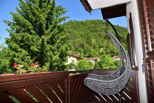 a wicker chair on a balcony with a tree at Apartment JANG in Tolmin