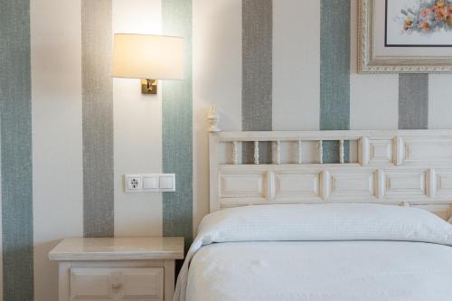 a bedroom with a bed and a lamp and a table at Villa Covelo in Poio