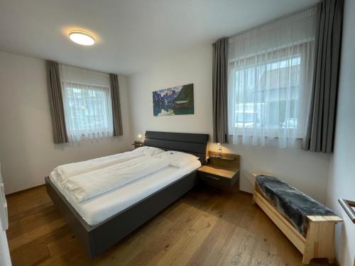 - une chambre avec un grand lit et 2 fenêtres dans l'établissement Oberkircher - zentral gelegen mit Museumobilcard, à Fundres
