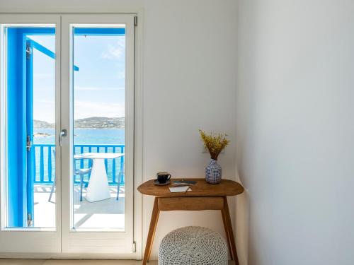 a table with a vase on it next to a door at Bluetopia Suites in Mýkonos City