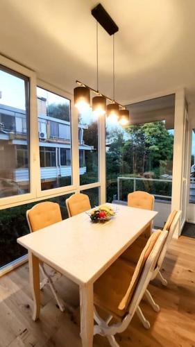 a dining room with a white table and chairs at renoviertes Reihenhaus am Radweg in Lignano in Bevazzana