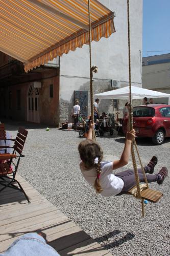 a young girl is playing on a swing at Pension Ferdinand Panzio in Sfântu-Gheorghe
