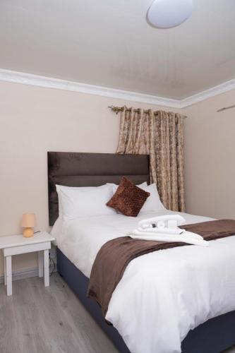a bedroom with a large white bed and a table at 40 on King BnB in East London