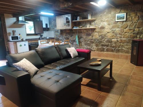 sala de estar con sofá de cuero y mesa en Cabaña Jerreru (vivienda vacacional), 
