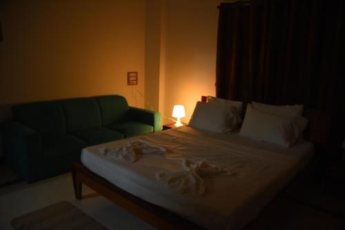 Dormitorio con cama con sofá y lámpara en Solis Stay, en Solapur