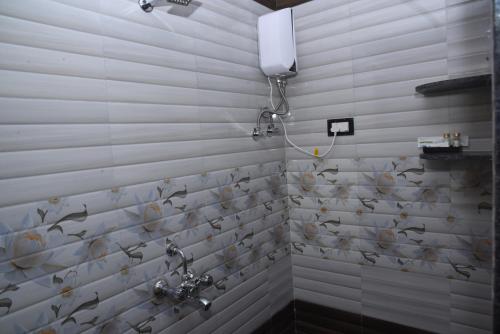 ein Badezimmer mit zwei Waschbecken und Vögeln an der Wand in der Unterkunft Solis Stay in Solapur