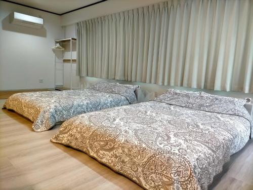 Minpaku 123 - Vacation STAY 15837 في ناسوشيوبارا: سريرين يجلسون بجانب بعض في غرفة النوم