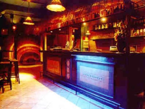 a bar in a restaurant with a bar counter at AgriHotel Papaya in San Pietro Apostolo