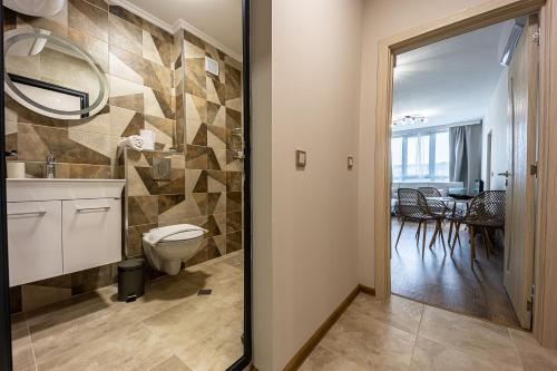a bathroom with a toilet and a sink and a table at City Center Apartments in Kŭrdzhali