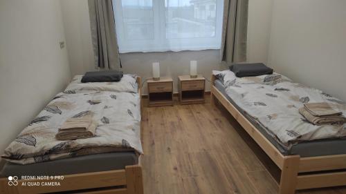 2 Betten in einem Zimmer mit 2 Nachttischen in der Unterkunft Privát Ivanka in Levice