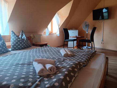1 dormitorio con 1 cama con toallas en Diána Fogadó en Keszthely
