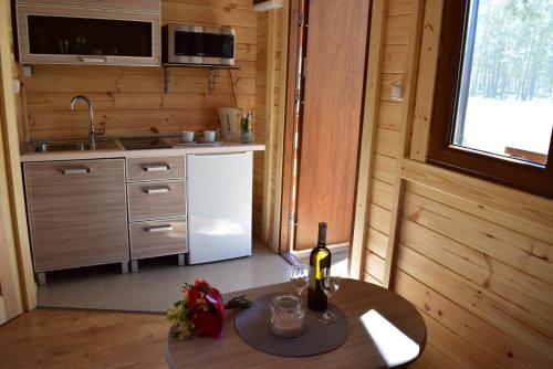 a kitchen with a table with a bottle of wine at NAVIGATOR Energetyk in Rowy