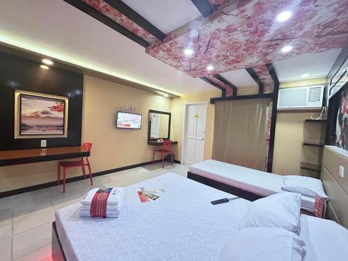 Santa RosaにあるHotel Sogo Sta Rosaのベッド2台と机が置かれた寝室