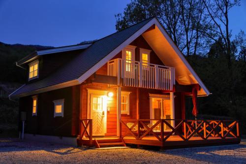 a small cabin with a porch and a balcony at 果樹園グランピングヴィラHARASAWA in Minakami