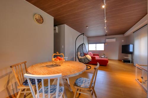 a room with a table and chairs and a living room at 果樹園グランピングヴィラHARASAWA in Minakami