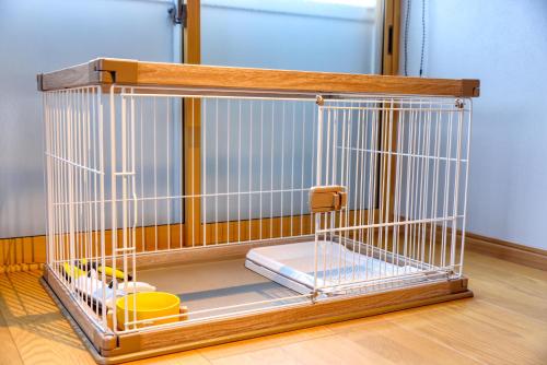 a cage with toys in it on a wooden floor at 果樹園グランピングヴィラHARASAWA in Minakami