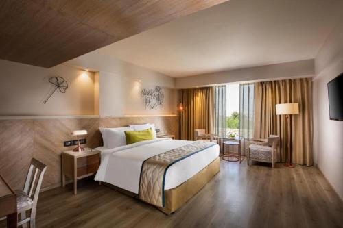 Habitación de hotel con cama grande y escritorio. en Airport hotel deep palace near international airport, en Nueva Delhi