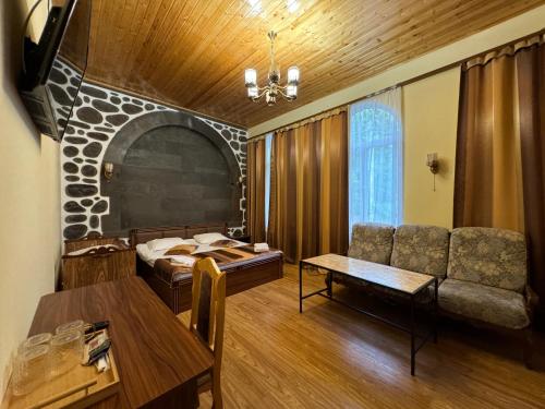 ein Wohnzimmer mit einem Bett und einem Tisch in der Unterkunft Kirch Hotel & Restaurant in Goris