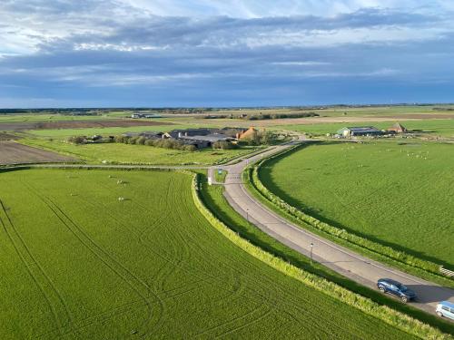 an aerial view of a road in a green field at Bed and Breakfast Oomes Huus in Den Hoorn