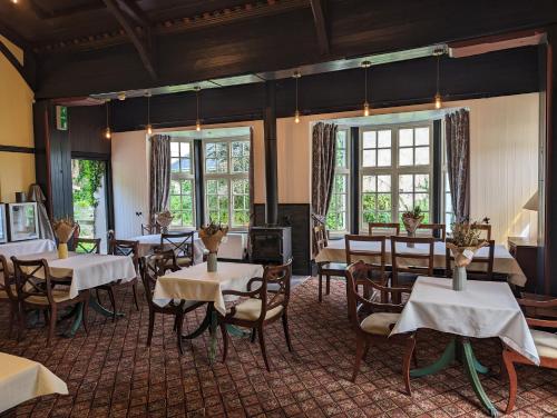 a dining room with tables and chairs and windows at The Chelsea in Llandudno