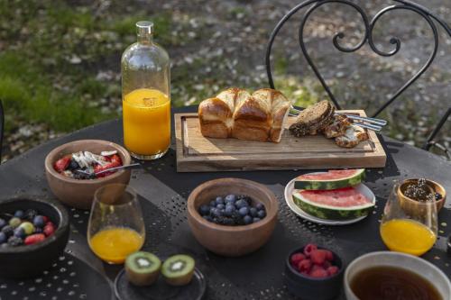 un tavolo con colazione a base di pane, frutta e succo d'arancia di Maison de Magescq a Magescq