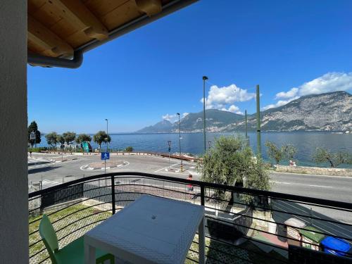 a balcony with a table and a view of the water at Camping Antonio in Brenzone sul Garda