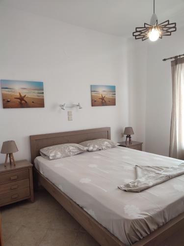 1 dormitorio con 1 cama, 2 mesitas de noche y 2 lámparas en ANATOLI ROOMS SERIFOS en Serifos