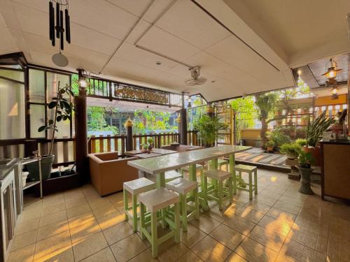 Baan Baramee House في شيانج راي: مطعم مع طاولة وكراسي في غرفة
