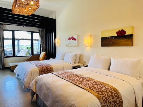 a hotel room with two beds and a window at Kenting Summerland Garden Resort in Eluan